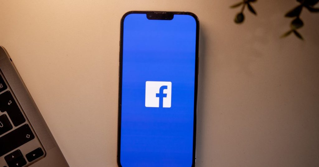 phone on a table with the facebook app opening