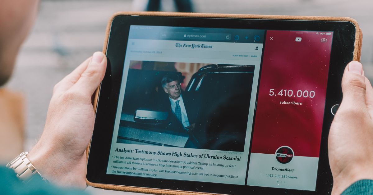 man holding an ipad with an article open